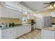 Bright kitchen featuring white cabinets, granite countertops, stainless steel appliances, and brick flooring at 31 N Algonquian St, Aurora, CO 80018