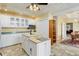 Spacious kitchen with white cabinetry, an island, and a view into the adjacent dining area at 31 N Algonquian St, Aurora, CO 80018