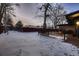 Snowy backyard with footprints and a view of a deck and fence at 6127 S Westview St, Littleton, CO 80120