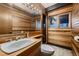 Clean bathroom with wood-paneled walls and a tiled floor at 6127 S Westview St, Littleton, CO 80120