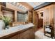 Mid-century bathroom with wood vanity, tile flooring, and a large mirror at 6127 S Westview St, Littleton, CO 80120