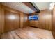 Simple bedroom with wood floors, wood paneled walls, and a window at 6127 S Westview St, Littleton, CO 80120