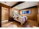 Mid-century bedroom with wood floors and wood paneled walls at 6127 S Westview St, Littleton, CO 80120