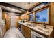 View of mid-century kitchen with granite countertops, stainless steel appliances, and wood cabinetry at 6127 S Westview St, Littleton, CO 80120