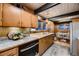 Mid-century modern kitchen features granite countertops, stainless steel appliances, and wood cabinetry at 6127 S Westview St, Littleton, CO 80120