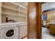 Functional laundry room with washer, dryer, and shelving at 6127 S Westview St, Littleton, CO 80120