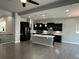 Modern kitchen with black cabinets, a kitchen island, stainless steel appliances, and wood floors at 10137 Atlanta St, Parker, CO 80134