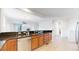 Open kitchen with stainless steel dishwasher, dark countertops and wood cabinetry at 16224 Cirque Mountain Way, Broomfield, CO 80023