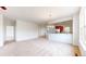 Open-concept living room with plush carpet, neutral paint, and a kitchen with wood cabinets in background at 16224 Cirque Mountain Way, Broomfield, CO 80023