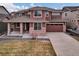 Inviting two-story home with brick and siding, a welcoming front porch, and a two-car garage at 20830 Scenic Park Dr, Parker, CO 80138