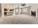 Bright living room with a cozy fireplace, neutral carpet, and seamless connection to the kitchen at 20830 Scenic Park Dr, Parker, CO 80138