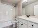 Bright bathroom featuring white tile, modern fixtures, and a single sink vanity at 2267 Peregrine Dr, Brighton, CO 80601