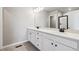 Bathroom featuring double vanity with sleek cabinetry, black hardware, and shower with glass door at 2267 Peregrine Dr, Brighton, CO 80601