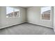 Bright bedroom features neutral walls, soft carpet, and large windows for ample natural light at 2267 Peregrine Dr, Brighton, CO 80601