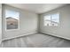 Bright bedroom features neutral walls, soft carpet, and large windows for ample natural light at 2267 Peregrine Dr, Brighton, CO 80601
