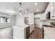 Bright kitchen featuring white cabinets, stainless appliances, a spacious island, and wood grain flooring at 2267 Peregrine Dr, Brighton, CO 80601