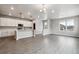 Open-concept living area showcasing wood-grain flooring and ample natural light from multiple windows at 2267 Peregrine Dr, Brighton, CO 80601
