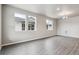 Bright living room featuring wood-grain flooring and multiple windows that provide plenty of natural light at 2267 Peregrine Dr, Brighton, CO 80601