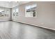 Bright living room featuring wood-grain flooring and multiple windows that provide plenty of natural light at 2267 Peregrine Dr, Brighton, CO 80601