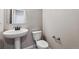 Cozy powder room featuring a pedestal sink and a toilet, designed with neutral colors at 2267 Peregrine Dr, Brighton, CO 80601