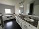 Bathroom featuring double sinks, white cabinets, a tub, and vanity at 6100 Bluestem # 238, Frederick, CO 80530