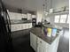 Bright kitchen featuring white cabinets, mosaic backsplash, and large center island at 6100 Bluestem # 238, Frederick, CO 80530