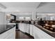 Modern kitchen with white cabinets, black countertops, a breakfast bar, and stainless steel appliances at 1940 Blake St # 300, Denver, CO 80202