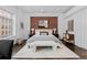 Main bedroom featuring a red brick accent wall, hardwood floors, and a comfortable king-size bed at 1940 Blake St # 300, Denver, CO 80202