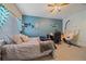 Well-lit bedroom with calming blue wall, a ceiling fan, and a unique hammock chair at 14700 E 104Th Ave # 1602, Commerce City, CO 80022