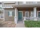 Inviting front porch with green door, decorative shutters, and manicured shrubbery at 14700 E 104Th Ave # 1602, Commerce City, CO 80022