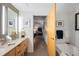 Bright bathroom boasting double vanity sinks, modern lighting fixtures, and a soaking tub with tile surround at 2100 16Th St # 606, Denver, CO 80202