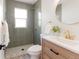 Modern bathroom with stylish tiling, natural wood vanity, shower, and a large mirror at 3728 W Exposition Ave, Denver, CO 80219