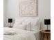 This bedroom features bright white decor, modern bedside tables, and contemporary abstract art at 3728 W Exposition Ave, Denver, CO 80219
