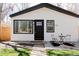 Shows the charming exterior with a modern black door, crisp white siding and cozy bistro set on the front patio at 3728 W Exposition Ave, Denver, CO 80219