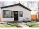 Exterior view of a well-kept home with black trim, white siding, and a cozy front patio bistro set at 3728 W Exposition Ave, Denver, CO 80219