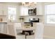 Bright eat-in kitchen with stainless steel appliances, white cabinetry and modern lighting at 3728 W Exposition Ave, Denver, CO 80219
