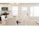 Bright eat-in kitchen with stainless steel appliances, white cabinetry and modern lighting at 3728 W Exposition Ave, Denver, CO 80219
