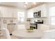 Bright kitchen features white cabinets, stainless appliances, quartz counters, and a stylish gold light fixture at 3728 W Exposition Ave, Denver, CO 80219