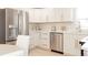 Bright kitchen features white cabinets, stainless appliances, quartz counters, and gold hardware at 3728 W Exposition Ave, Denver, CO 80219