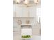 Bright kitchen features white cabinets, stainless appliances, quartz counters, and a stylish gold light fixture at 3728 W Exposition Ave, Denver, CO 80219