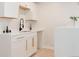Modern wet bar with white cabinetry, quartz countertops, black faucet and brass pulls at 3728 W Exposition Ave, Denver, CO 80219