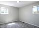 An empty bedroom offers neutral paint, new carpet, and two windows at 11937 Claude Ct, Northglenn, CO 80233