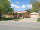 Charming brick home with a detached garage and a well-manicured front yard on a sunny day at 11937 Claude Ct, Northglenn, CO 80233