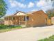 A charming brick house with a detached garage and a long driveway on a sunny day at 11937 Claude Ct, Northglenn, CO 80233