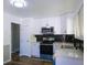 Modern kitchen featuring sleek, white cabinets, stainless steel appliances, and a dark backsplash at 11937 Claude Ct, Northglenn, CO 80233