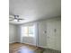 Bright living room features wood floors, a ceiling fan, and a large window for natural light at 11937 Claude Ct, Northglenn, CO 80233