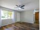 Bright living room featuring stylish wood flooring, a ceiling fan, and a large window for natural light at 11937 Claude Ct, Northglenn, CO 80233