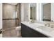 Bathroom featuring sleek dual vanities, tiled walls, and a walk-in glass shower at 4200 W 17Th Ave # 223, Denver, CO 80204
