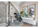 A bright bathroom showcasing a clawfoot tub, pedestal sink, and black framed shower at 21531 Main Ave, Golden, CO 80401