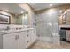 Bathroom featuring double sinks, white vanity, a glass-enclosed shower and marble wall at 21531 Main Ave, Golden, CO 80401